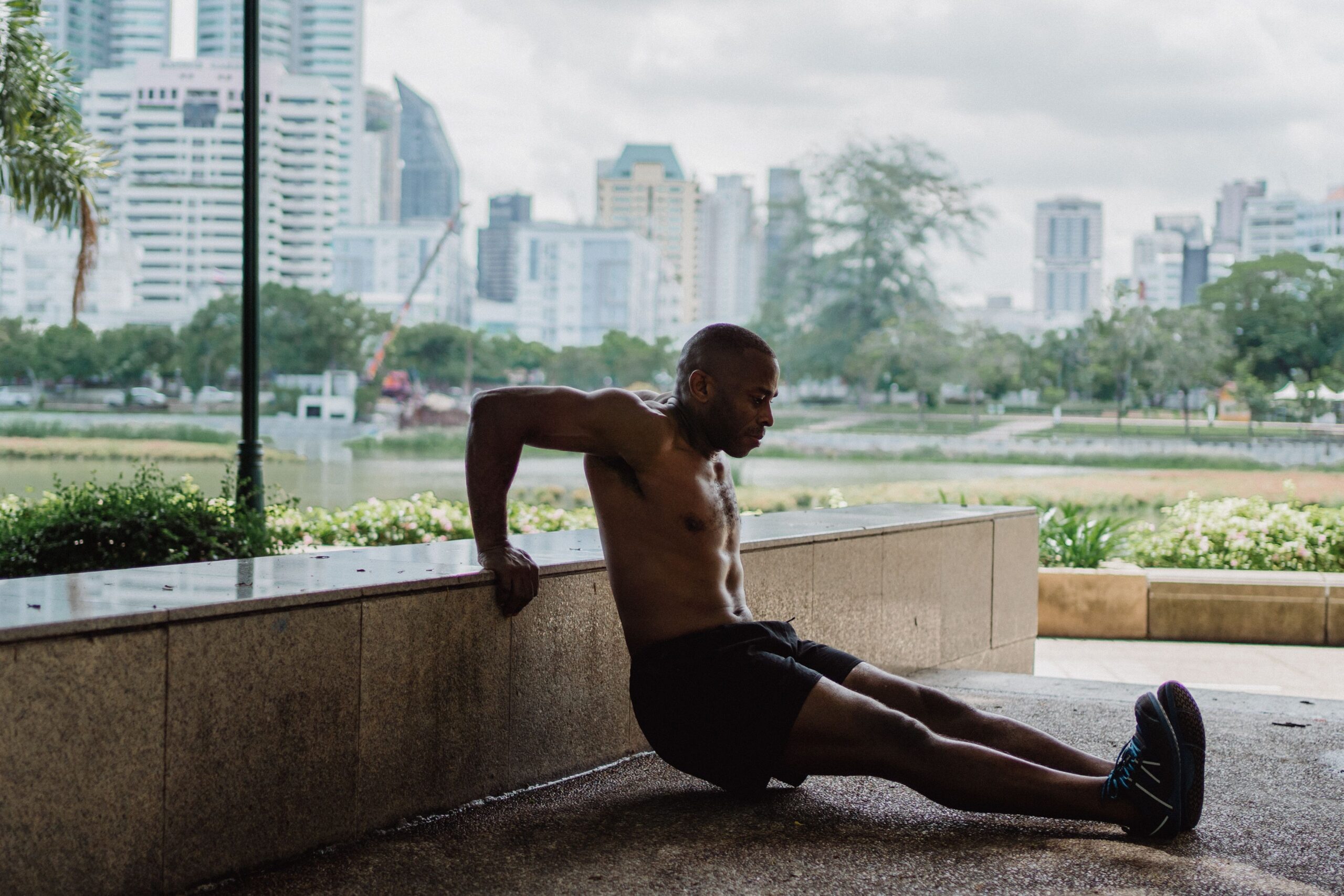 Man performing bench dips outdoors to build triceps strength and upper-body fitness.